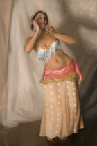 Bellydancer in red and yellow with her arms raised